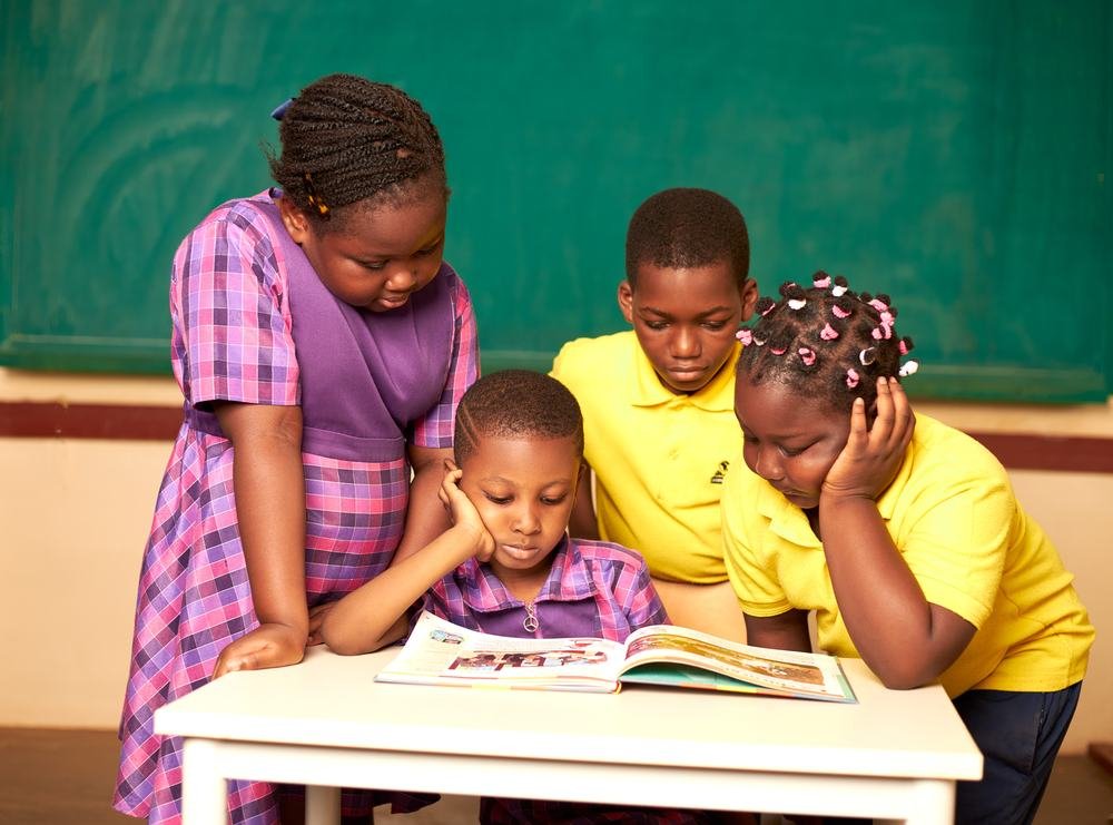 Élèves de primaire lisant ensemble un livre en classe